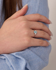 Stainless steel silver-tone solitaire ring with aqua blue gemstone worn on hand