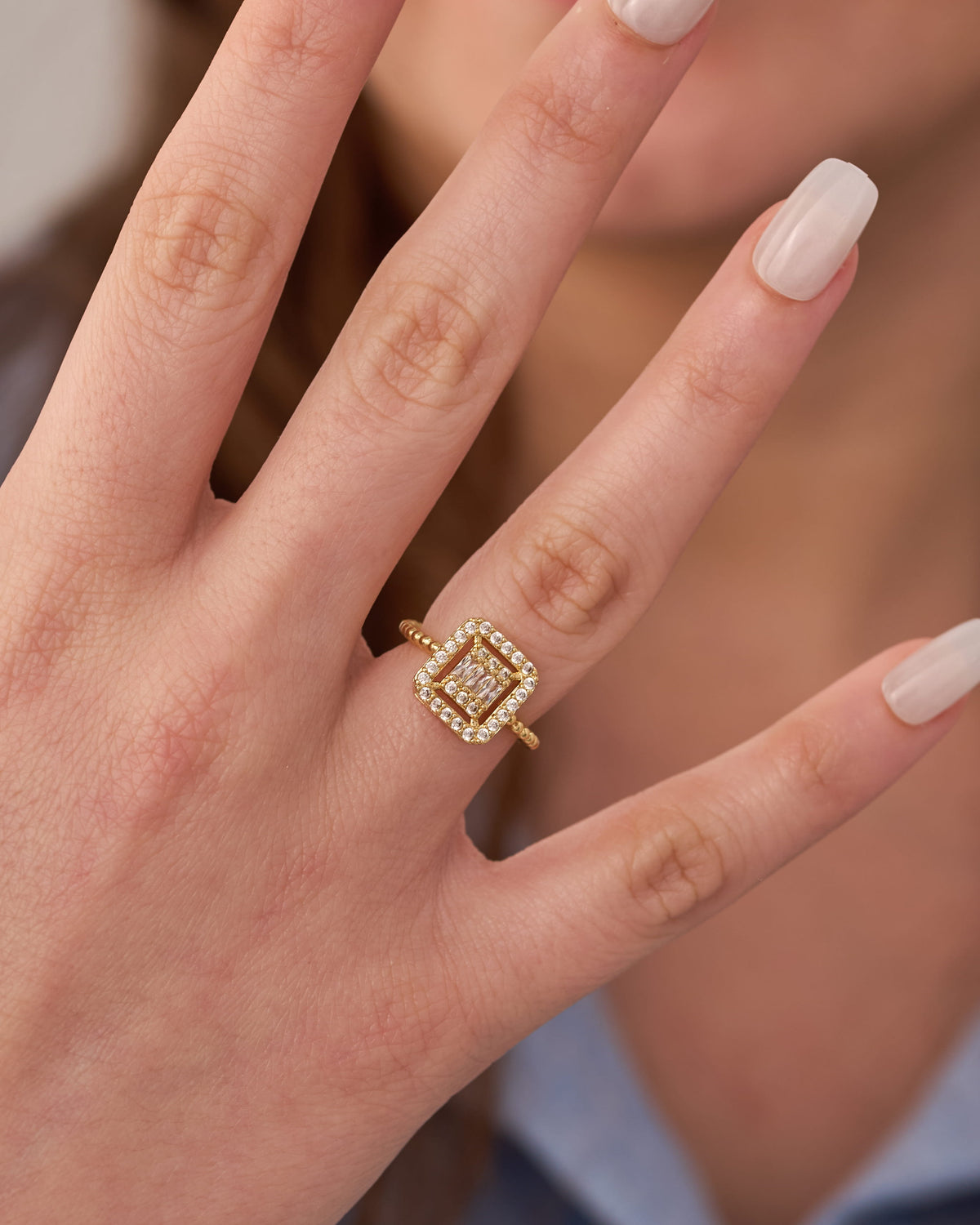 Stainless steel gold-tone square halo crystal ring with beaded band detail worn on finger