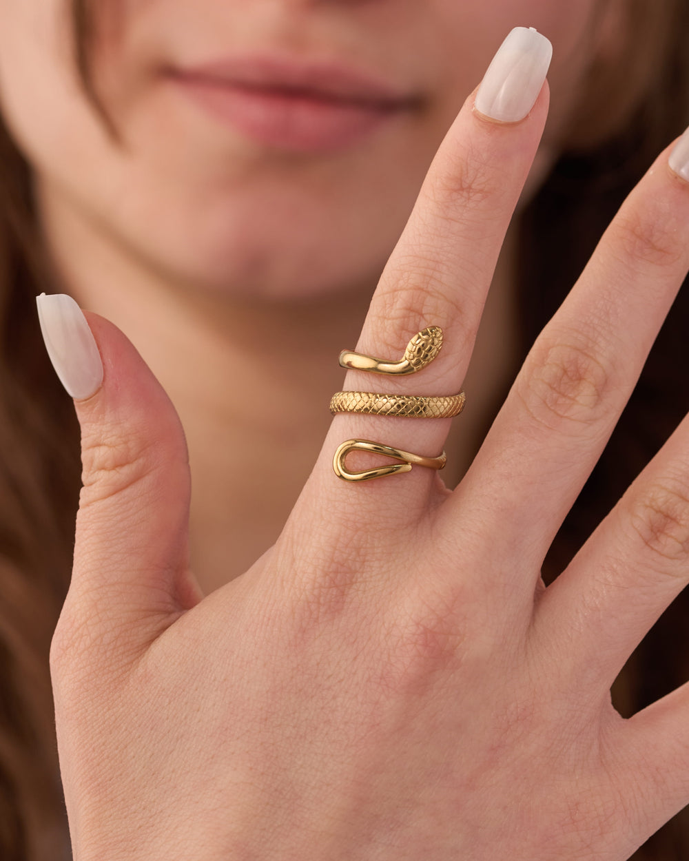 Stainless steel gold-tone snake wrap ring and textured band ring worn on fingers
