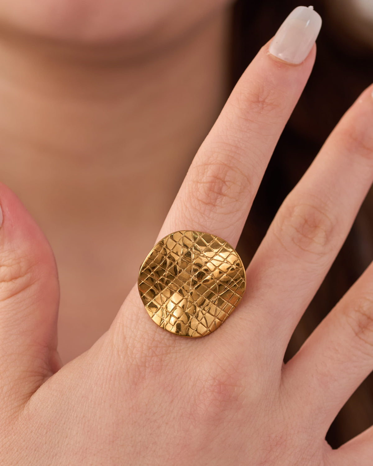 Stainless steel gold-tone hammered textured dome cocktail ring worn on finger