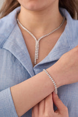 Stainless steel crystal Y-drop necklace and adjustable tennis bracelet set styled on a blue shirt