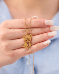 Stainless steel gold-tone cat pendant necklace held in hand