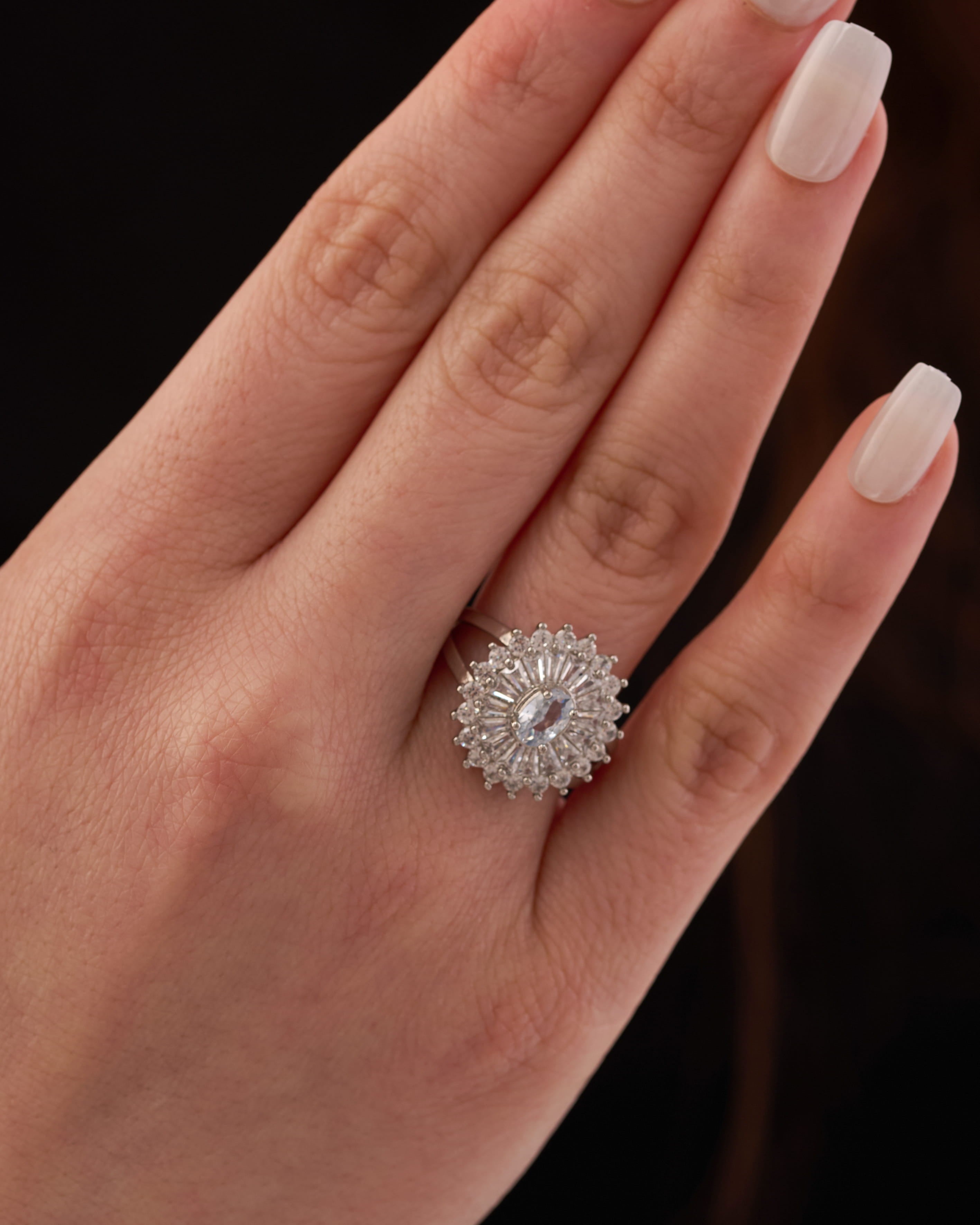Stainless steel silver-tone vintage oval halo cocktail ring with baguette crystal surround on finger