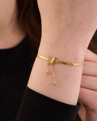 Stainless steel gold-tone herringbone chain bracelet with butterfly clasp detail on wrist