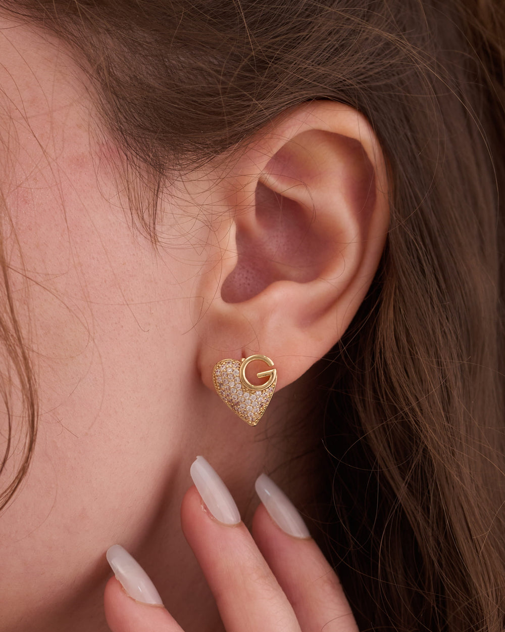 Stainless steel gold-tone textured heart-shaped stud earring worn on ear